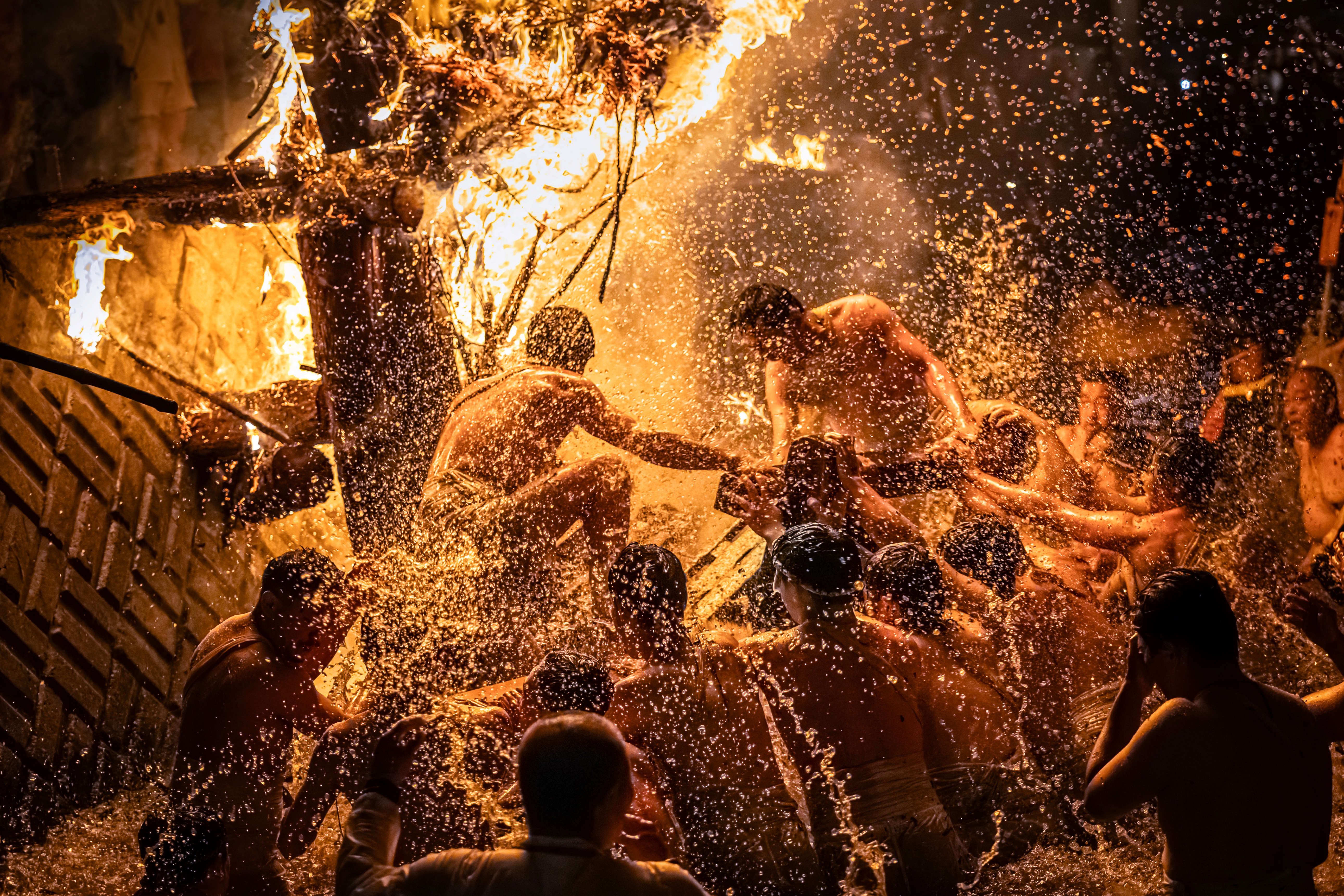 The Abare Festival in Japan's Noto region. This image captures the festival’s finale, as men leap into the river amidst fiercely burning torches that send sparks flying everywhere.