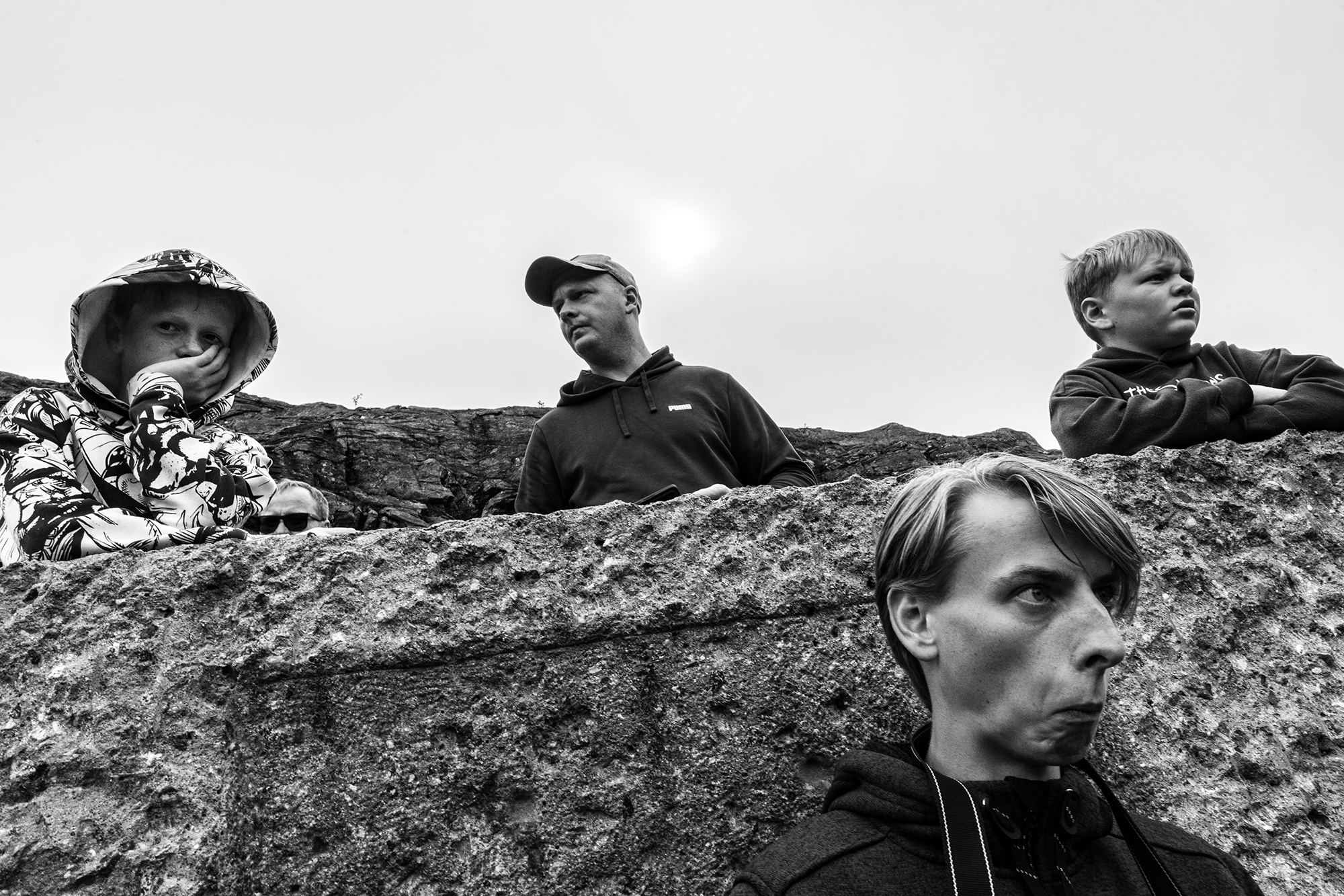 Four people with distinct expressions on their faces are photographed reacting to a view.